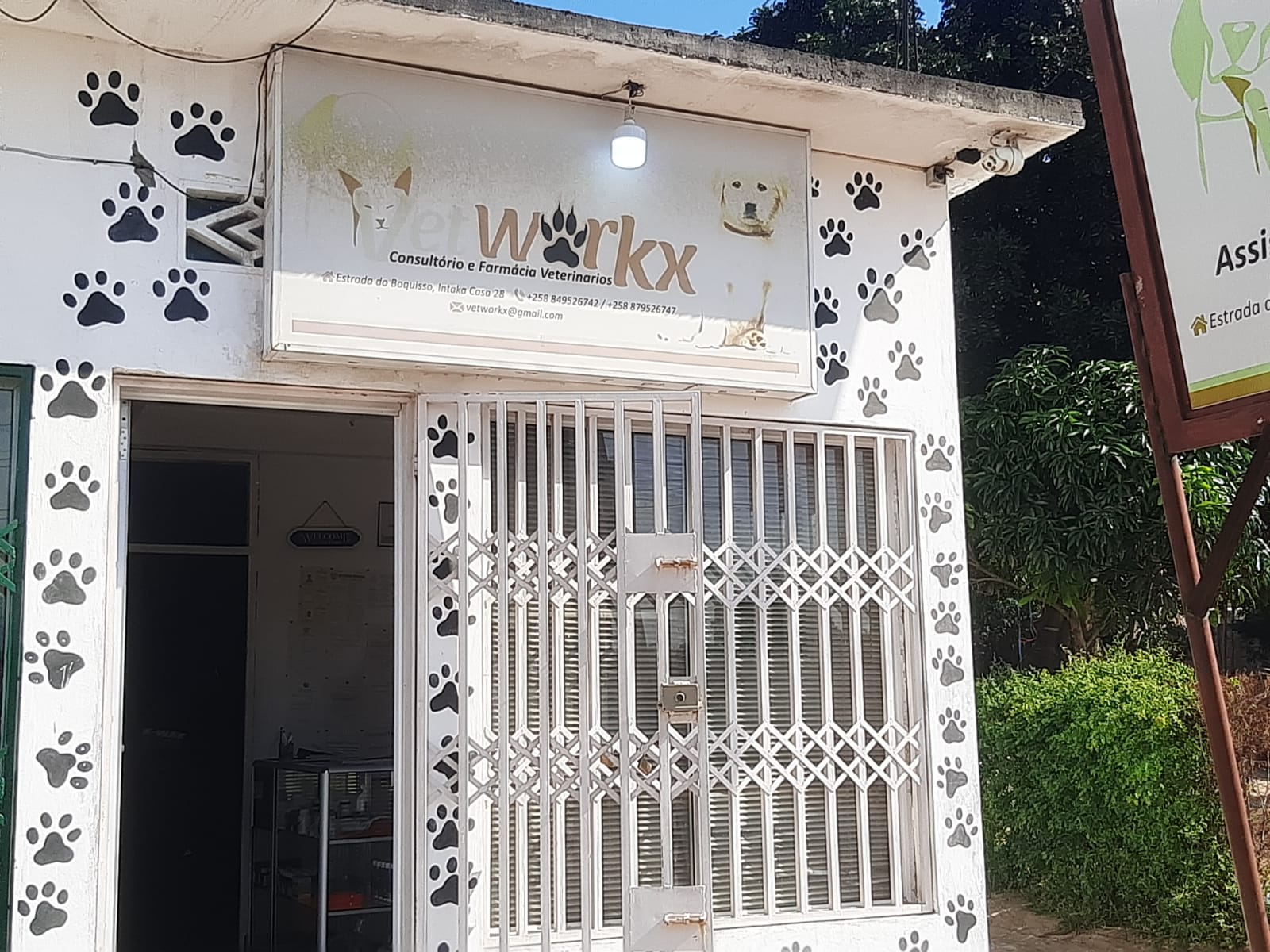 Fachada da farmácia veterinária VetWorkx em Intaka, Maputo — entrada com placa e gradeamento branco
